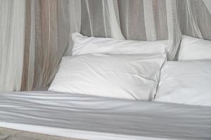 almofadas confortáveis brancas na cama foto