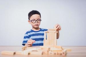 menino asiático brincando com um quebra-cabeça de madeira foto