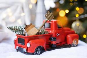 carro retrô vermelho com uma árvore de natal decora com a chave da casa na caminhonete para o natal. compra de uma casa, mudança, hipoteca, empréstimo, imóveis, clima festivo, ano novo foto