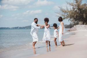 conceito de família de férias de verão. família feliz caminhando e brincando juntos na praia foto