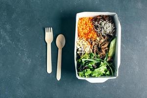 recipiente de embalagem reutilizável com almoço asiático - carne, macarrão, misture folhas verdes, brotos, legumes