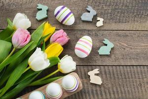 ovos de páscoa, coelhinho de madeira, flores de tulipas. conceito de feriado de páscoa foto