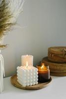 velas acesas aconchegantes na prateleira branca. conceito de decoração de interiores de casa de inverno ou outono