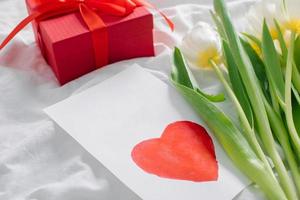 dia da mulher, conceito de dia das mães. tulipas brancas, presente, cartão com texto eu amo a mãe foto