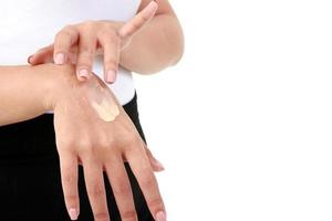 as mulheres jovens aplicam creme nutritivo na pele do dorso da mão para que fique úmida, não seca. conceito de beleza e cuidados de saúde