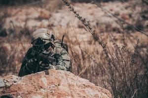 soldados das forças especiais em guerras no deserto, povo tailandês, soldado do exército usa laptop para ver mapa com satélite, usando rádio para comunicação durante operação militar foto