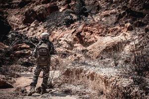 soldados das forças especiais em guerras no deserto, povo tailandês, soldado do exército usa laptop para ver mapa com satélite, usando rádio para comunicação durante operação militar foto