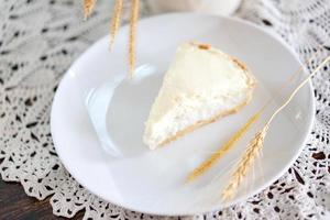 torta de creme de coco transparente no prato sobre a mesa de madeira sem nada em cima. atirando na luz do sol. foto