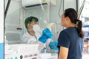 homem asiático foi testado pela equipe médica em pressão negativa para teste de covid-19 em campo externo. foto