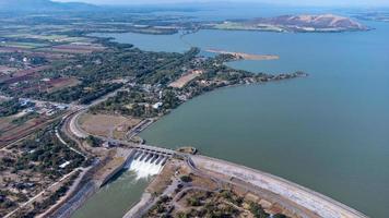 uma vista aérea sobre a barragem de pasak jolasid, província de lopburi, tailândia. acompanhando o movimento das comportas que estão liberando água em canais rurais em enormes quantidades de água. foto