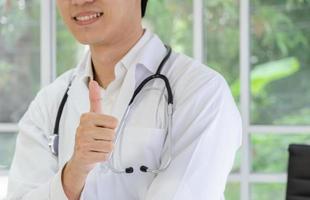 médico masculino sorridente, mostrando sinal de polegar para cima foto