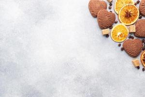 biscoitos de coração de chocolate, canela de laranja e especiarias picantes em uma mesa cinza, vista superior, copie o espaço. foto