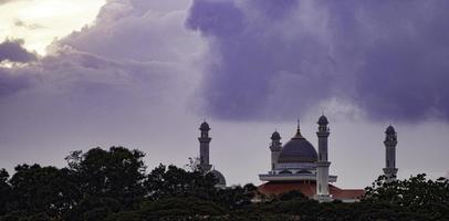 uma vista da mesquita de marang com belas nuvens e pôr do sol foto