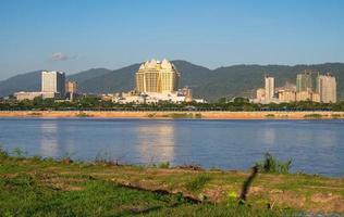 o grande cassino e outros edifícios na província de bokeo em laos view olham através do rio mekong do distrito de chiang saen, na fronteira com a tailândia. foto