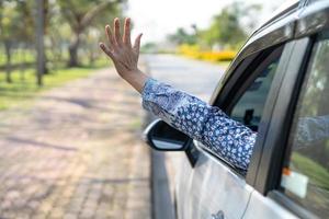 feliz desfrutar e liberdade na viagem de viagem com a mão da mãe levantada da janela do carro nas férias de verão foto