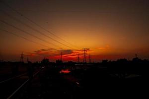 silhueta de postes elétricos de alta tensão com paisagens coloridas após o pôr do sol foto