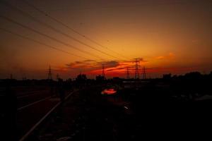 silhueta de postes elétricos de alta tensão com paisagens coloridas após o pôr do sol foto