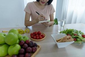 comida saudável e dieta cetônica. as mulheres planejam dietas para uma forma esbelta e saudável. mulher comendo maçã e legumes