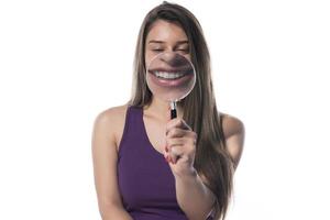 mulher rindo segura uma lupa na frente de sua boca foto