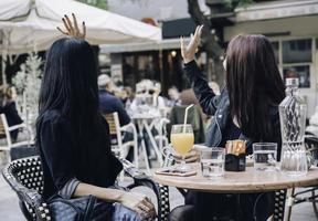 duas namoradas felizes olhando para a vitrine em pé com sacolas de compras perto do shopping foto