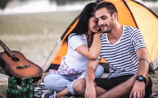 casal à beira de um lago em piquenique romântico foto