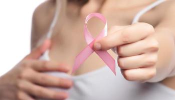 outubro rosa mês de conscientização do câncer de mama, mão de mulher segura fita rosa foto