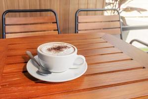 café com leite em xícara branca na mesa foto