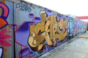arte de rua. imagem de fundo abstrata de uma pintura de graffiti completa em tons de bege e laranja com o trem do metrô foto