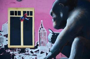imagem detalhada do desenho de graffiti de cor. fundo de arte de rua de fundo com um macaco pintado, olhando a cidade através de uma lupa foto