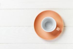 copo colorido vazio no prato para café ou chá em fundo de madeira foto