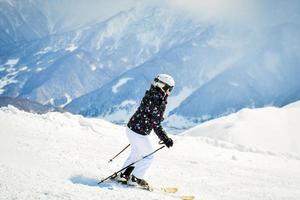 esquiadora iniciante esquiando em declive nas montanhas cênicas do cáucaso solo em declive íngreme foto