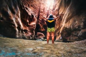 turista feminina desfruta do desfiladeiro do rio de wadi mujib com incríveis cores claras douradas. wadi mujib está localizado na área do mar morto na jordânia foto