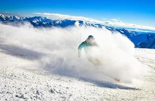 esquiador masculino esqui extremo downhill passe lado super rápido em condições de neve para gôndola com fundo de montanhas. destino de viagem georgia cáucaso foto