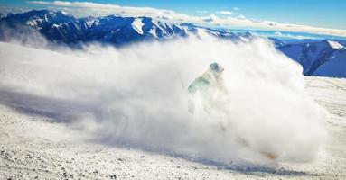 imagem dinâmica de um esquiador na pista nos Alpes. esquiador de mulher na neve macia. férias de inverno ativas, esquiar em declive em dias ensolarados. passeios de esqui na pista com redemoinhos de neve fresca foto