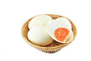 ovos de pato branco na cesta isolado no ovo salgado de fundo branco foto
