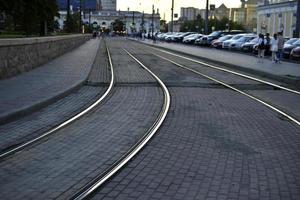 os trilhos de ferro do bonde da cidade à noite. cidade da noite. transporte urbano e rodoviário. foto