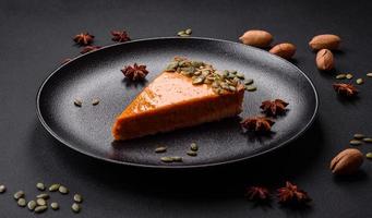 bela saborosa torta de abóbora com fatias em uma placa de cerâmica preta foto