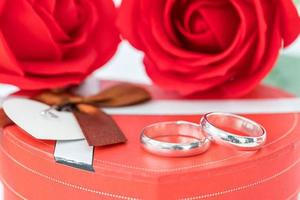 anel de casamento e caixa em forma de coração em branco foto