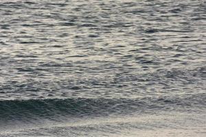 praia deserta e deserta com mar calmo e ondas pequenas foto