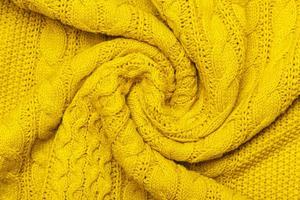 foto macro amarela brilhante de jersey texturizado e tricô de suéter ou moletom. padrão e plano de fundo para o conceito de outono quente de moda