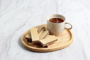 bolacha de chocolate na placa de madeira, servida com chá foto