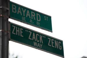 placa verde da rua bayard sob chuva forte em chinatown, cidade de nova york foto