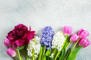 dia das mães ou conceito de dia da mulher. jacinto, tulipas e flores de peônia em fundo de concreto claro. cartão de primavera. configuração plana, vista superior, copie o espaço. foto
