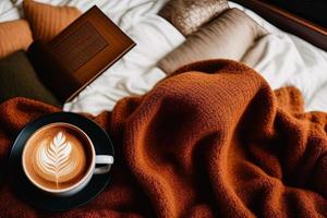um livro em cima de uma cama ao lado de uma xícara de café