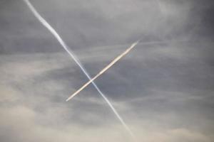 avião voando no céu azul entre nuvens e luz solar foto