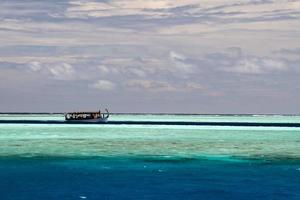 barco dhoni maldivo no oceano azul foto