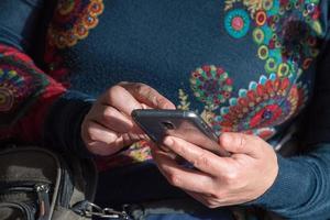 mãos ao enviar mensagens de texto no smartphone celular foto