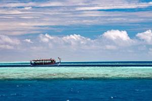 barco dhoni maldivo no oceano azul foto