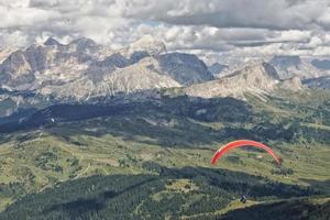 parapente voando no panorama das dolomitas foto