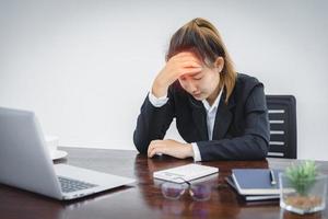 garota estressada sentindo dores de cabeça devido ao excesso de trabalho do computador ou funcionários de estilo de vida sedentário que estão cansados de trabalhar no escritório, síndrome do escritório. foto